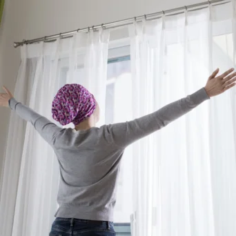 woman opening curtains